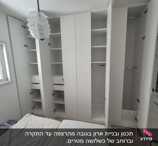 ארון בגדים לבן עם דלתות פתוחות בחדר שינה